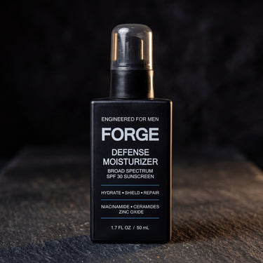 FORGE Defense Moisturizer SPF 30 bottle on dark slate lit by warm directional light
