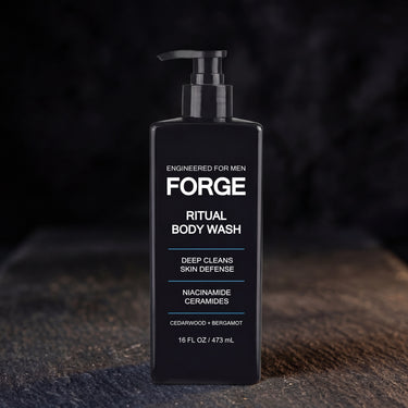 FORGE Ritual Body Wash 16 oz pump bottle on dark slate lit by warm directional light